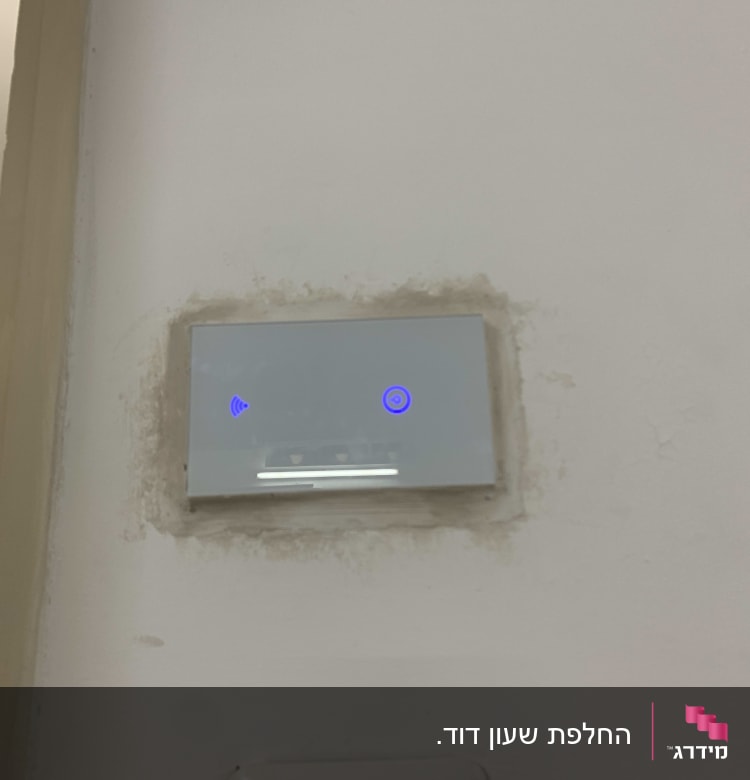 מתג חשמלי עם תאורה כחולה על קיר